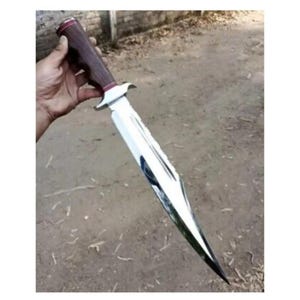 K&ouml;nnte beinhalten: Ein silbernes Jagdmesser mit einem braunen Holzgriff. Das Messer hat eine lange, scharfe Klinge und eine spitze Spitze.