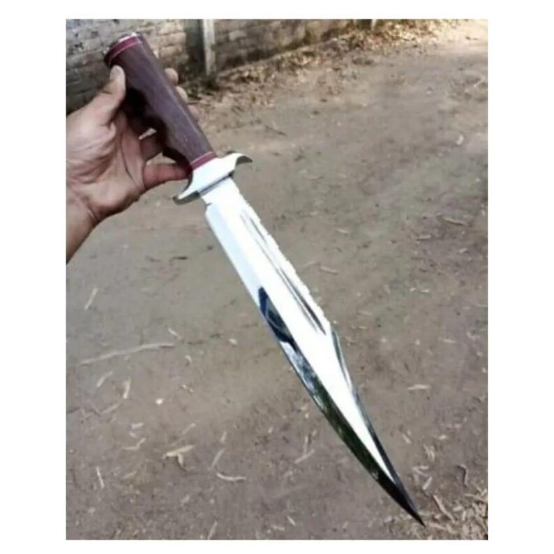 K&ouml;nnte beinhalten: Ein silbernes Jagdmesser mit einem braunen Holzgriff. Das Messer hat eine lange, scharfe Klinge und eine spitze Spitze.