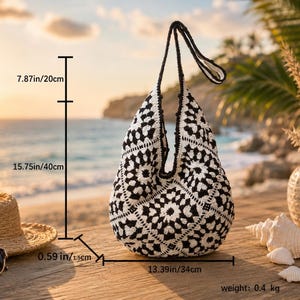 Pode incluir: Uma bolsa de ombro de croch&ecirc; preta e branca com um padr&atilde;o de motivo floral. A bolsa tem uma al&ccedil;a de 20 cm, altura de 40 cm, largura de 34 cm, espessura de 1,5 cm e um peso total de 0,4 kg.