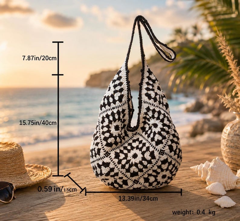 Pode incluir: Uma bolsa de ombro de croch&ecirc; preta e branca com um padr&atilde;o de motivo floral. A bolsa tem uma al&ccedil;a de 20 cm, altura de 40 cm, largura de 34 cm, espessura de 1,5 cm e um peso total de 0,4 kg.