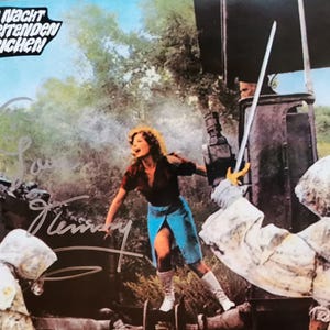 Może przedstawiać: Vintage kadr filmowy z "Die Nacht der reitenden Leichen" przedstawiający kobietę w czerwonym topie i niebieskiej spódnicy, trzymającą miecz. Obraz zawiera podpisy i postacie w kapturowych płaszczach, z tytułem filmu u góry.