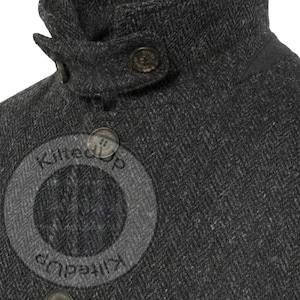Puede incluir: Primer plano de una chaqueta de tweed gris oscuro con cuello alto y detalles de botones. La chaqueta tiene un aspecto texturizado y cierre de botones. El cuello est&aacute; dise&ntilde;ado para mantenerse erguido. El texto "Kiltedup" es visible.