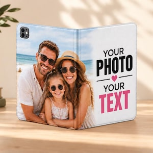 May include: A foldable tablet case featuring a custom photo of a family on the beach on the left panel and the black and pink text "YOUR PHOTO" with a small pink heart and "YOUR TEXT" on the right panel, with a camera cutout on the top left.