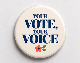 May include: A round pinback button with a cream-colored background. The text "YOUR VOTE, YOUR VOICE" is printed in dark blue capital letters. Below the text, there is a small graphic of an orange flower with a dark blue center and green leaves.
