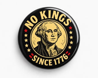 May include: A circular pin-back button featuring a black background with a central illustration of George Washington in cream. The text NO KINGS is arched above and SINCE 1776 below in cream, flanked by red and cream stars on both sides.
