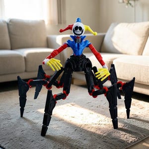 Puede incluir: Una figura de juguete articulada multicolor que se asemeja a un híbrido entre un bufón y una araña. La figura tiene una cara blanca con forma de calavera con una amplia sonrisa, un torso azul y rojo, brazos rojos, manos amarillas y patas negras con articulaciones rojas. Está posada sobre una alfombra clara.