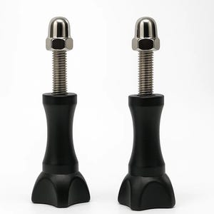 May include: Two black metal bolts with silver threaded shafts and rounded silver nuts. The bolts have a flared base and a cylindrical body. The background is plain white.