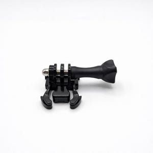 May include: A black action camera mount with a quick-release buckle and a pivoting arm. The mount has a silver metal screw and is designed to attach to various surfaces. The mount is made of durable plastic.