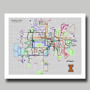 May include: A detailed map of Champaign-Urbana, Illinois, featuring colorful bus routes. The map includes the text "Champaign-Urbana" and the coordinates 40° 6' 54" N, 88° 14' 32" W. An orange "I" logo is in the lower right corner.