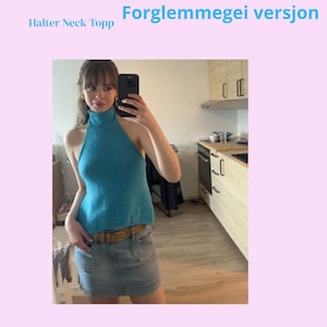 Puede incluir: Se muestra un top turquesa con cuello halter y cuello alto. Se combina con una falda vaquera y un cinturón marrón. El texto "SOLSIKKEGLØD" y "LARSEN.KE" se muestran en la imagen.