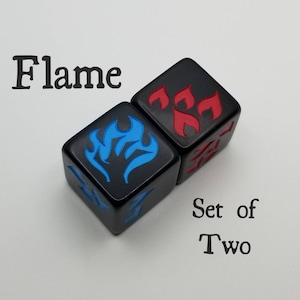 May include: Set of two black dice with blue and red flame designs. The dice are labeled "Flame" and "Set of Two".