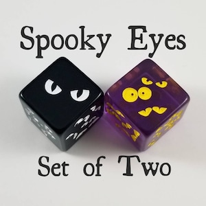 Puede incluir: Conjunto de dos dados con diseños de ojos espeluznantes. Un dado es negro con ojos blancos y el otro es morado con ojos amarillos. Los dados están etiquetados como "Spooky Eyes Set of Two".
