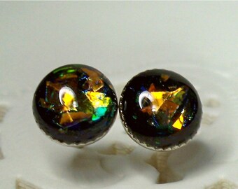 May include: A pair of silver stud earrings with black and iridescent glass cabochons. The cabochons have a mix of gold, green, and blue colours.