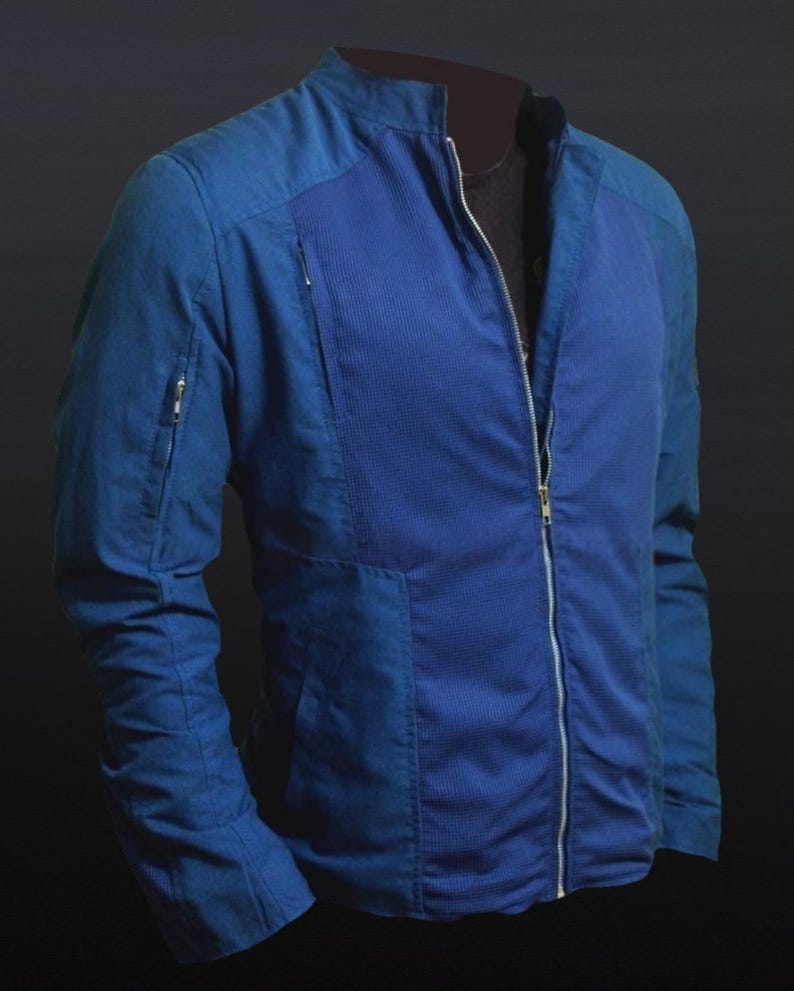 May include: A blue jacket with a full-length zipper and a stand-up collar. The jacket has a ribbed texture on the front panel and a zippered pocket on the left sleeve. The jacket is a solid blue color.