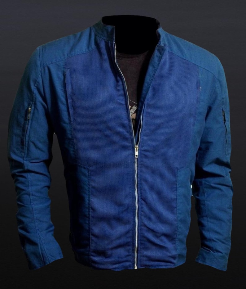 May include: A blue jacket with a full-length zipper and a stand-up collar. The jacket has a textured, ribbed design on the front and smooth panels on the shoulders and sleeves. It features two zippered pockets on the sleeves.