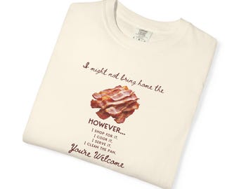 May include: A cream-colored t-shirt featuring a graphic of cooked bacon strips in the center. The text reads: I might not bring home the HOWEVER... I shop for it. I cook it. I serve it. I clean the pan. You're Welcome. The shirt has a crew neck.