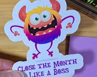 May include: A colorful sticker featuring a cartoon monster with orange, yellow, and purple hues. The monster has large eyes and a wide grin. The sticker reads "CLOSE THE MONTH LIKE A BOSS" in purple text.