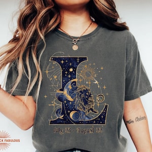 Leo Zodiac Sign celestial lion graphic on a Comfort Colors 1717 t-shirt featuring gold moon phases, stars, and cosmic artwork with July 23–August 22 text. Astrology-inspired graphic tee available in multiple colors and sizes S to 4XL. Perfect gift for Leo birthdays, horoscope lovers, and boho celestial fashion.