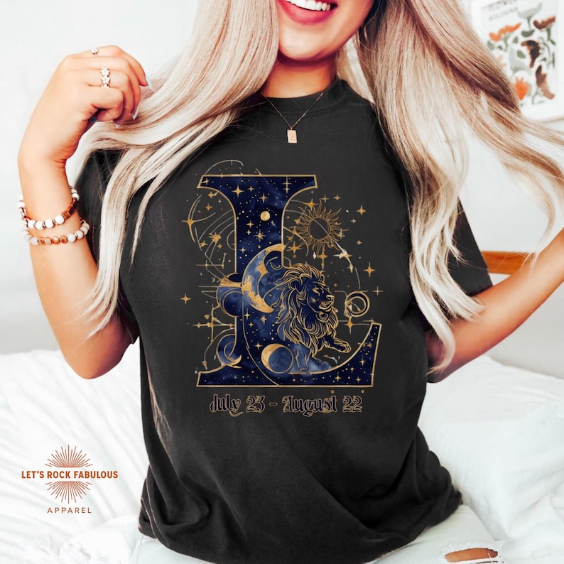 Leo Zodiac Sign celestial lion graphic on a Comfort Colors 1717 t-shirt featuring gold moon phases, stars, and cosmic artwork with July 23–August 22 text. Astrology-inspired graphic tee available in multiple colors and sizes S to 4XL. Perfect gift for Leo birthdays, horoscope lovers, and boho celestial fashion.