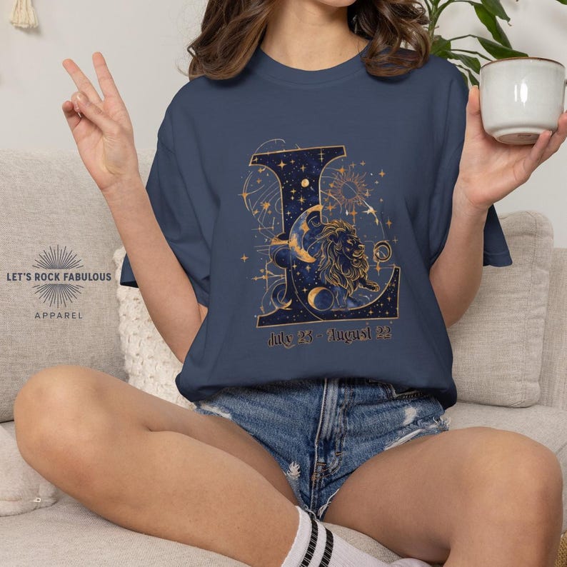 Leo Zodiac Sign celestial lion graphic on a Comfort Colors 1717 t-shirt featuring gold moon phases, stars, and cosmic artwork with July 23–August 22 text. Astrology-inspired graphic tee available in multiple colors and sizes S to 4XL. Perfect gift for Leo birthdays, horoscope lovers, and boho celestial fashion.