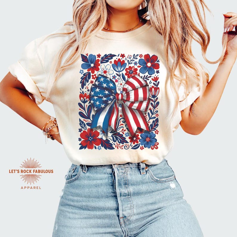 Boho floral American flag bow t-shirt on Comfort Colors 1717 unisex tee. Patriotic 4th of July shirt for women featuring red white and blue bow with floral design. Available in sizes S, M, L, XL, 2XL, 3XL, 4XL and multiple color options including ivory, white, navy, pepper, blossom, and chambray. Perfect America 250th Anniversary tee, Independence Day outfit, summer BBQ, and casual Americana style.