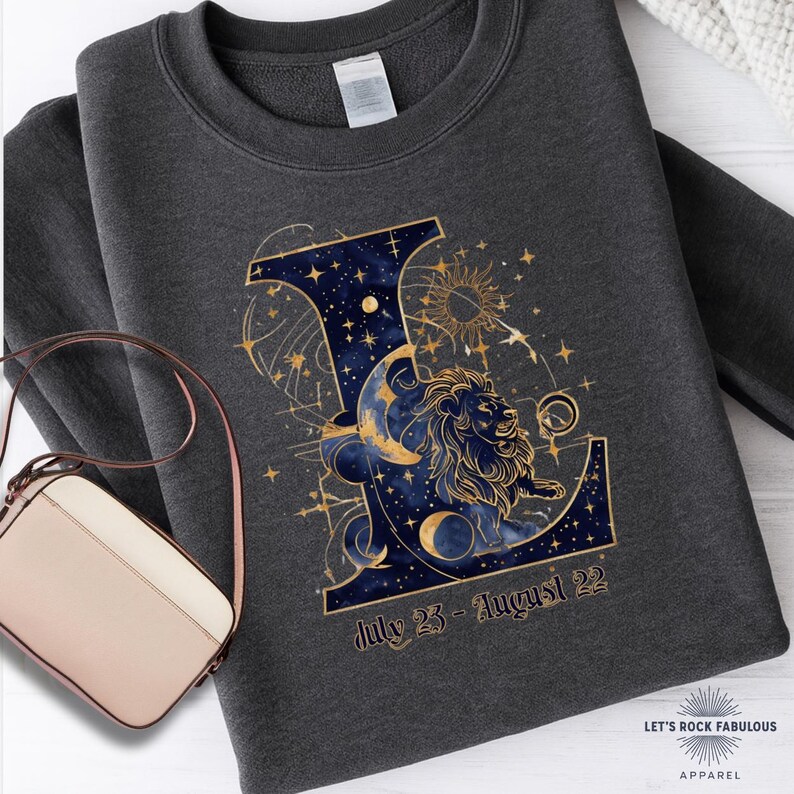 Leo Zodiac Sign celestial lion graphic on a Gildan sweatshirt featuring gold moon phases, stars, and cosmic artwork with July 23–August 22 text. Astrology-inspired graphic crewneck available in multiple colors and sizes S to 4XL. Perfect gift for Leo birthdays, horoscope lovers, and boho celestial fashion.