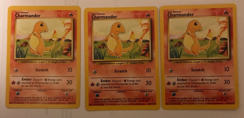 Puede incluir: Tres cartas de juego de Pok&eacute;mon vintage que representan a Charmander, un Pok&eacute;mon de tipo fuego. Cada carta tiene un fondo amarillo con texto rojo y negro. Las cartas presentan una ilustraci&oacute;n de Charmander con llamas naranjas en el fondo. El texto en las cartas incluye "Charmander", "Ara&ntilde;azo", "Brasas" y "Descarta 1 carta de Energ&iacute;a unida a Charmander para poder usar este ataque".