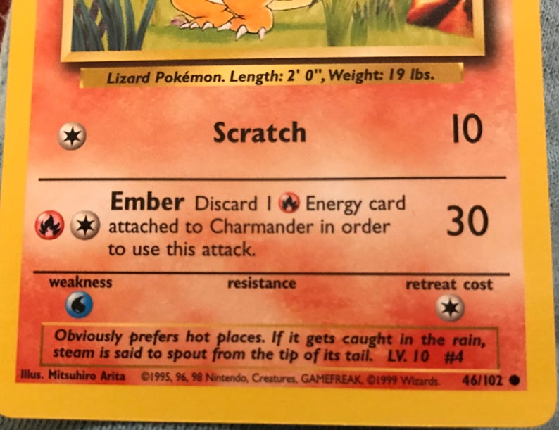 Puede incluir: Una carta de juego de Pokemon con Charmander, un Pokemon de tipo fuego. La carta es naranja y amarilla con un borde rojo. La carta tiene una imagen de Charmander en el frente y sus ataques, "Scratch" y "Ember", en la parte posterior. La carta es n&uacute;mero 46/102.