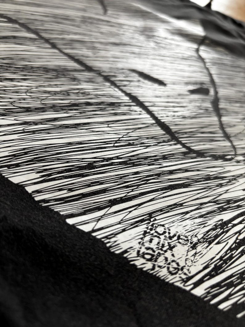 May include: Abstract black and white artwork featuring a pattern of parallel lines and ink splatters. The design has a textured appearance, with a combination of thick and thin lines. The artwork is on a white background with a black border.