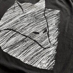 May include: Black t-shirt featuring a white, stylized illustration of a fox's head. The design uses a cross-hatching technique to create texture and depth. The text "love mix tapes" is printed at the bottom.
