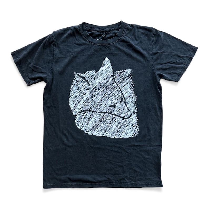 May include: Black t-shirt featuring a white, stylized fox graphic. The fox design is created with a series of parallel lines, giving it a textured appearance. The shirt has short sleeves and a crew neck.