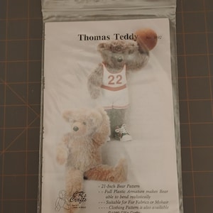 May include: A clear plastic bag containing a pattern for a teddy bear named Thomas Teddy. The pattern includes a 21-inch bear design, a bear wearing a basketball uniform, and the text "CR's Crafts".