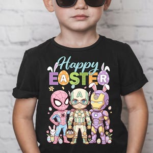 May include: Black t-shirt featuring the text "Happy Easter" with cartoon superheroes Spider-Man, Captain America, and Iron Man. The superheroes are depicted with bunny ears and holding Easter baskets. The shirt is worn by a young child wearing sunglasses.