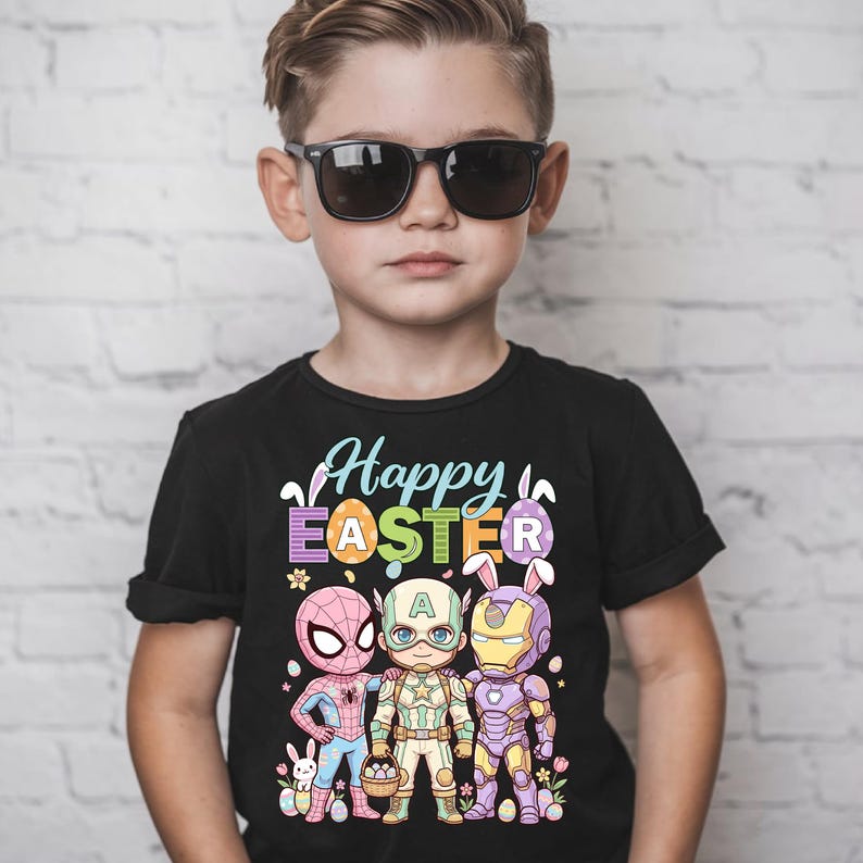 A young boy wearing a black t-shirt with a colorful graphic design featuring cartoon characters and the text "Happy Easter".