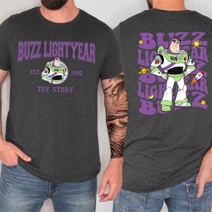 a man wearing a gray t-shirt with a design of Buzz Lightyear from the Toy Story franchise.
