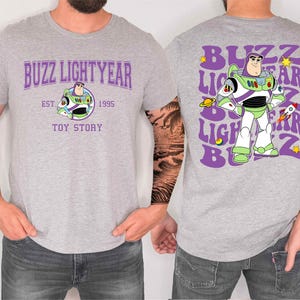 a man wearing a gray t-shirt with a design of Buzz Lightyear from the Toy Story franchise.