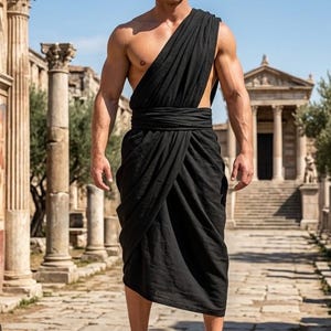 Könnte beinhalten: Ein schwarzes Kleidungsstück im Toga-Stil mit einseitigem Schulterdrapé und einer gewickelten Taillenschärpe, kombiniert mit braunen Leder-Gladiatorensandalen. Das Kleidungsstück besteht aus einem einfarbigen schwarzen Stoff.
