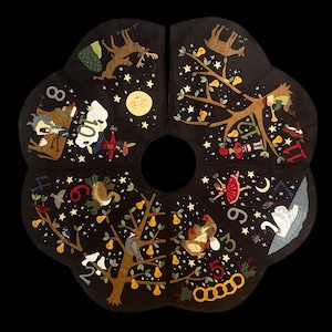 May include: A black Christmas tree skirt with a scalloped edge, featuring embroidered scenes from the Twelve Days of Christmas. The design includes pears, birds, dancers, and other festive elements, with numbers around the edge.
