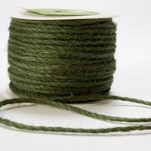 May include: A spool of olive green twine. The twine is tightly wound around a white cardboard core. A length of the twine extends from the spool, suggesting it is ready for use. The twine has a slightly rough texture.