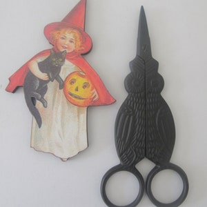 May include: Black metal owl-shaped scissors with a vintage Halloween image of a girl in a witch's hat holding a black cat and a jack-o'-lantern.