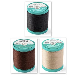 Puede incluir: Tres carretes de hilo Coats & Clark Artisanet Button & Craft en negro, marrón y beige. Cada carrete tiene una base y una parte superior turquesa con información del producto.