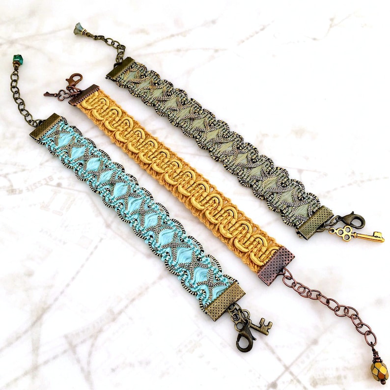 Puede incluir: Tres pulseras con dise&ntilde;os intrincados y cierres en forma de llave. Las pulseras est&aacute;n hechas de tejido tejido y cuentas en tonos de azul, dorado y verde.