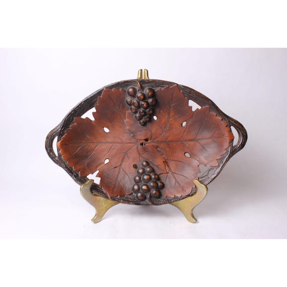 A hand-carved wooden bowl with intricate grape-leaf relief — the kind of vintage craft skill that's genuinely rare to find new.