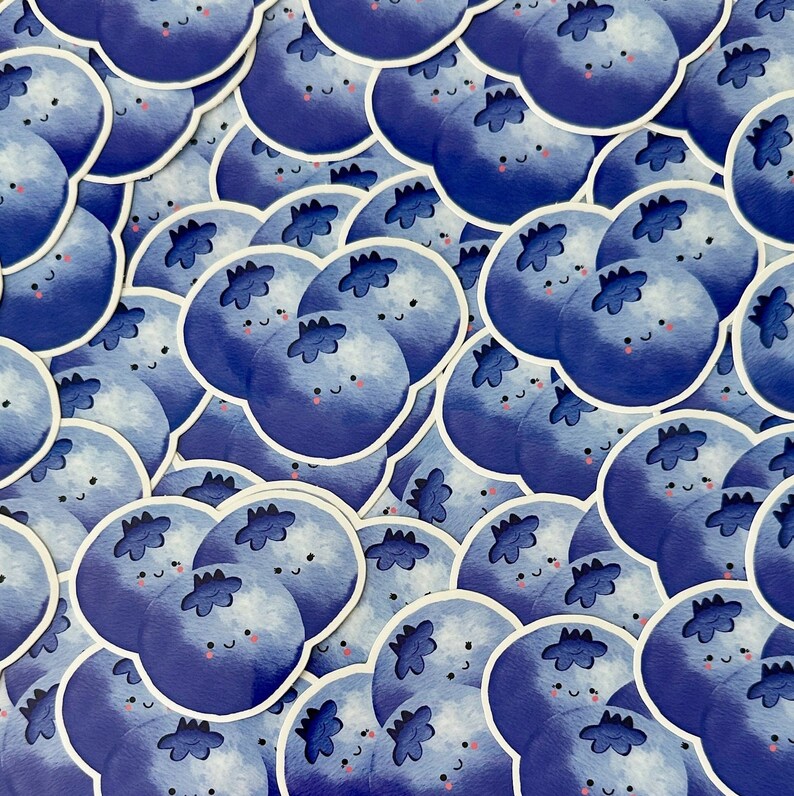 May include: A collection of blue blueberry stickers with cute faces. The stickers are arranged in a random pattern and are all different sizes.