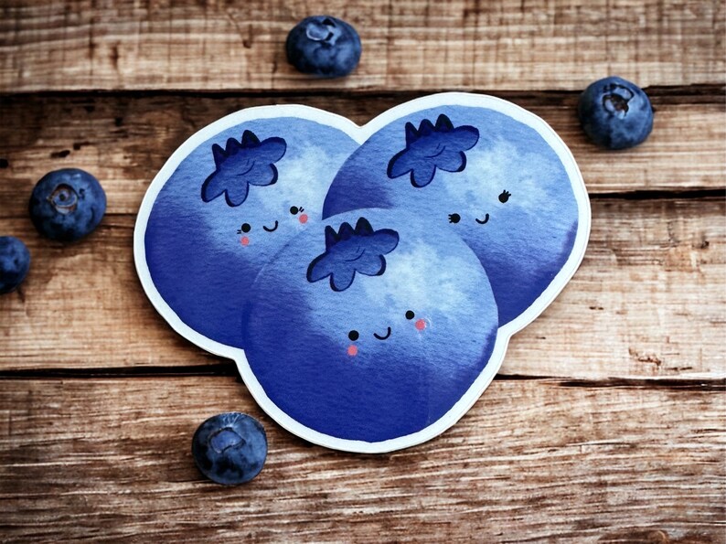 May include: Three blue cartoon blueberries with happy faces and white eyes. The blueberries are arranged in a cluster on a wooden surface.