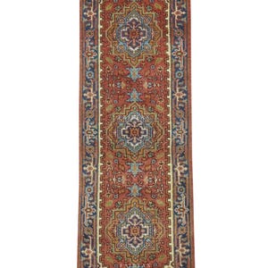 May include: A rectangular runner rug with a central red field and intricate geometric patterns in blue, beige, and gold. The rug features a border with floral motifs and the word "FAIRFAX" at both ends. The rug is designed for hallways or entryways.