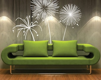 May include: A green sofa with two pillows sits in front of a wall with a white dandelion design. The text "decals murals" is in the top left corner of the image.
