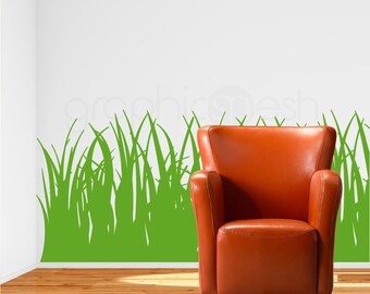 May include: A green grass silhouette wall decal with a brown leather armchair in front of a white wall. The decal is a simple design of grass blades.