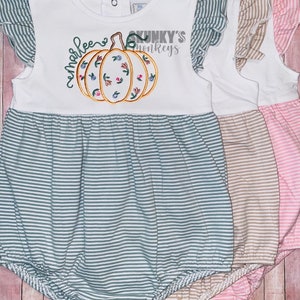 May include: Three baby onesies with a pumpkin design and the text "Sunkys Monkeys" on the front. The onesies are striped in gray, brown, and pink.