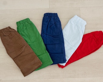 May include: Five pairs of pants in different colors: brown, green, blue, white, and red. The pants are all made of a soft, comfortable fabric and have a relaxed fit.